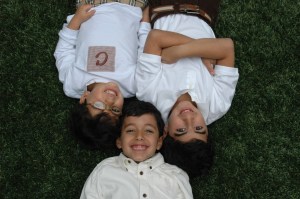 Photo of three young children playing in the grass in Atlanta GA: Moores Mill Dental