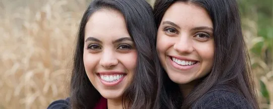 Photo of two teenaged girls, smiling with straight white teeth